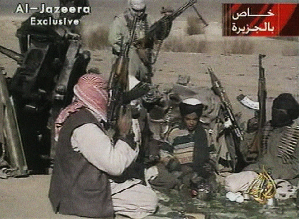 FILE - In this Nov. 5, 2001 image made from video broadcast by the Qatari-based television station Al-Jazeera, a young boy, center, identified as Hamza bin Laden, reads a poem about Taliban leader Mullah Mohammad Omar in Ghazni, Afghanistan. Years after the death of his father at the hands of a U.S. Navy SEAL raid in Pakistan, it is now Hamza bin Laden who finds himself squarely in the crosshairs of world powers. In rapid succession in recent weeks, the U.S. put a bounty of up to a $1 million for him; the U.N. Security Council named him to a global sanctions list, sparking a new Interpol notice for his arrest; and his home country of Saudi Arabia revealed it had revoked his citizenship. (AP Photo/Al-Jazeera via APTN, File)