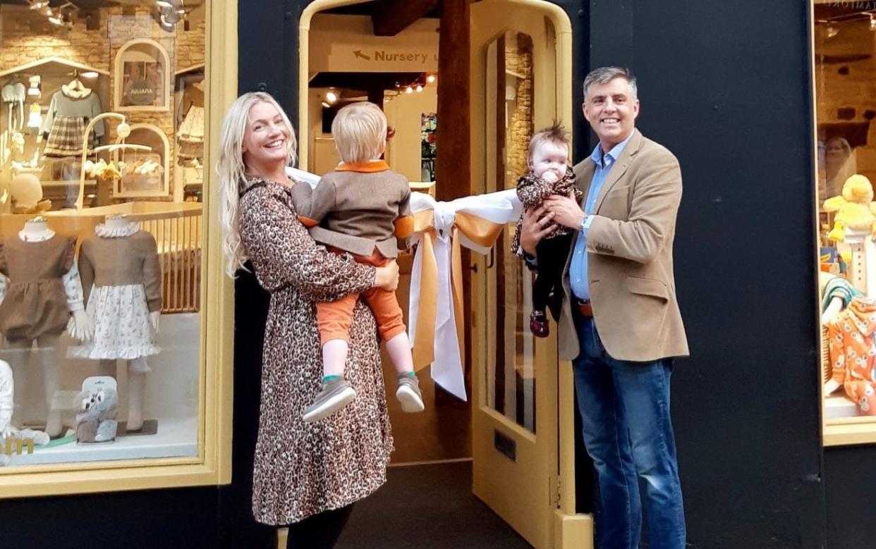 Marianne Rawlins with her husband Simon and children at the opening of her shop, which is painted black and a colour named 'Cherished Gold'