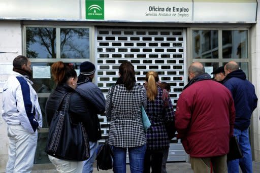 People wait in line in front of a government employment office in the Cruz Roja suburb of Sevilla. Spain has announced that its jobless rate surged to a record 24.4 percent at the end of March, pounding financial markets already reeling from a Spanish sovereign debt downgrade