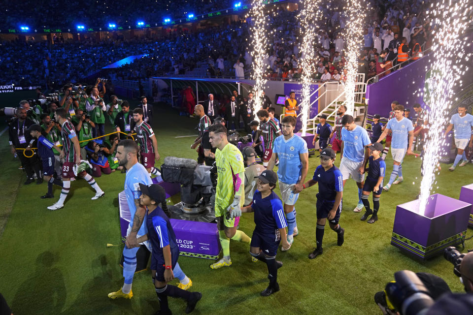 Manchester City players, foreground, and Fluminense players enter the pitch for the Soccer Club World Cup final match between Manchester City FC and Fluminense FC at King Abdullah Sports City Stadium in Jeddah, Saudi Arabia, Friday, Dec. 22, 2023. (AP Photo/Manu Fernandez)