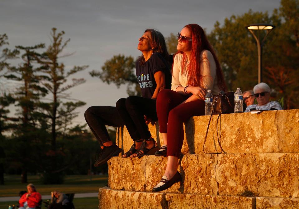 Des Moines Register columnists and Storytellers coaches Rekha Basu, left, and Courtney Crowder listen as Allen Juneau shares his story during the Des Moines Register Storytellers Project at Lauridsen Amphitheater at Water Works Park in Des Moines on Tuesday, Sept. 14, 2021.