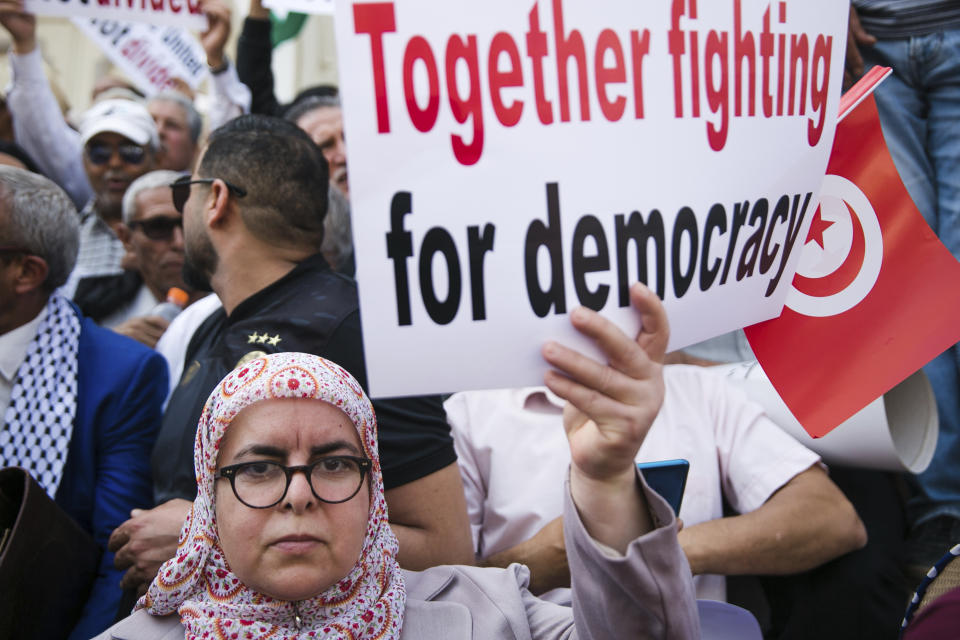 FILE - A woman holds up a banner during a protest against Tunisian President Kais Saied in Tunis, Tunisia, Sunday, May 15, 2022. Tunisia presidency says the North African country will hold its next presidential elections on Oct. 6. (AP Photo/Hassene Dridi, File)