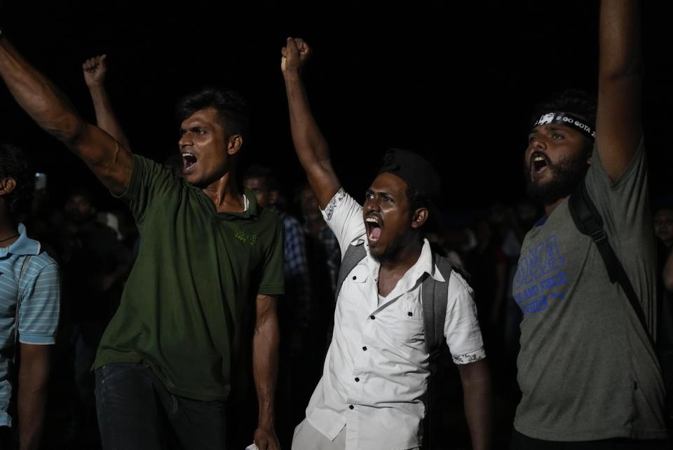 Sri Lankans celebrate as they react to early reports of President Gotabaya Rajapaksa's resignation in Colombo, Sri Lanka, Thursday, July 14, 2022. Embattled Rajapaksa fled a day earlier under pressure from demonstrators furious over the island nation’s economic collapse. He finally emailed his resignation Thursday, a day later than promised, according to an official. (AP Photo/Rafiq Maqbool)