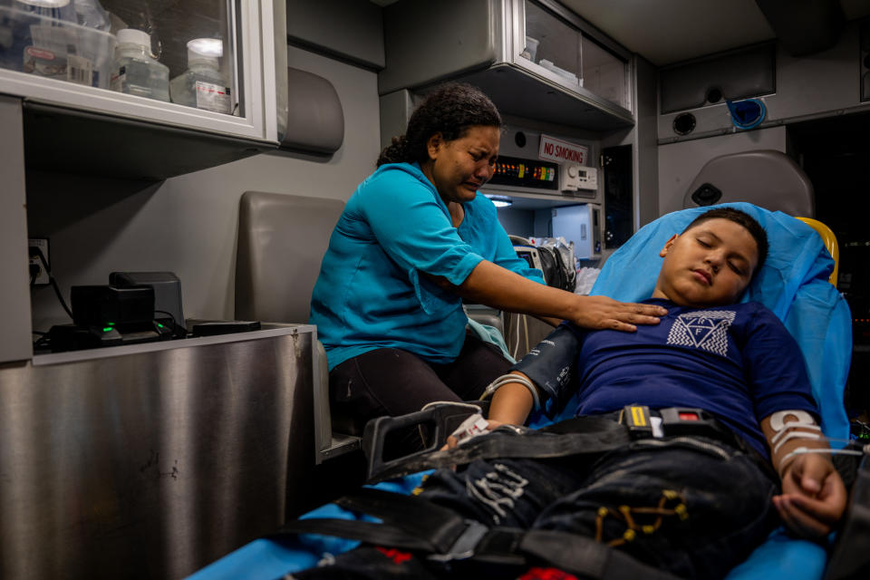  Victoria Varela places her hand on her son’s chest as he's treated for dehydration. 