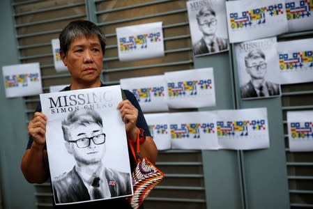 A woman holds a poster of Simon Cheng, a staff member at the consulate who went missing on August 9 after visiting the neighbouring mainland city of Shenzhen, during a protest outside the British Consulate-general office in Hong Kong