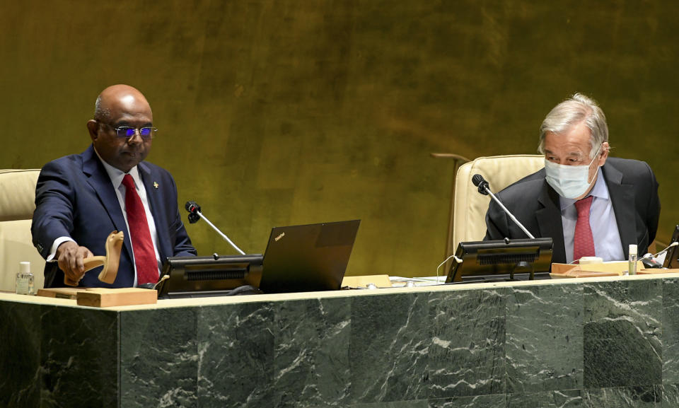 In this photo provided by United Nations, Abdulla Shahid, left, pounds the gavel signaling his start as the new president of the 76th session of the United Nations General Assembly, accompanied by Secretary-General António Guterres at U.N. headquarters on Tuesday, Sept. 14, 2021. (Evan Schneider/United Nations via AP)