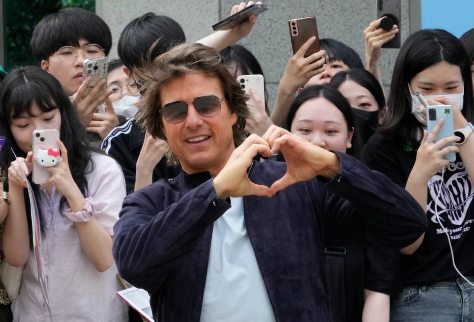 Tom Cruise poses as he arrives to promote his latest movie 