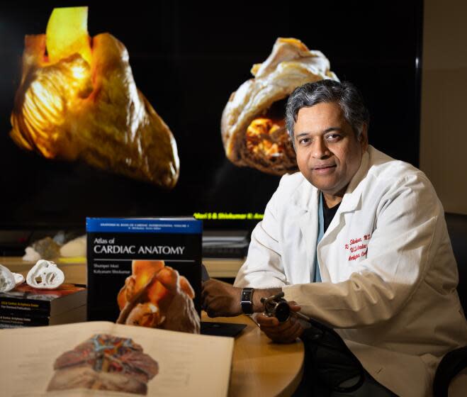 Westwood, CA - May 09: Dr. Kalyanam Shivkumar, Professor of Medicine, UCLA Cardiac Arrhythmia Center, shown with his book book titled "Atlas of Cardiac Anatomy" and a book by Dr. Eduard Pernkopf, an ardent Nazi whose anatomical book was drawn off the bodies of executed prisoners, shown in foreground. Dr. Kalyanam Shivkumar and others in the Amara Yad project are working to create a new set of anatomical images. Shivkumar wants their work to surpass that of Dr. Eduard Pernkopf, an ardent Nazi whose anatomical book was drawn off the bodies of executed prisoners. Photo taken at David Geffen School of Medicine at UCLA in Westwood Thursday, May 9, 2024. (Allen J. Schaben / Los Angeles Times)