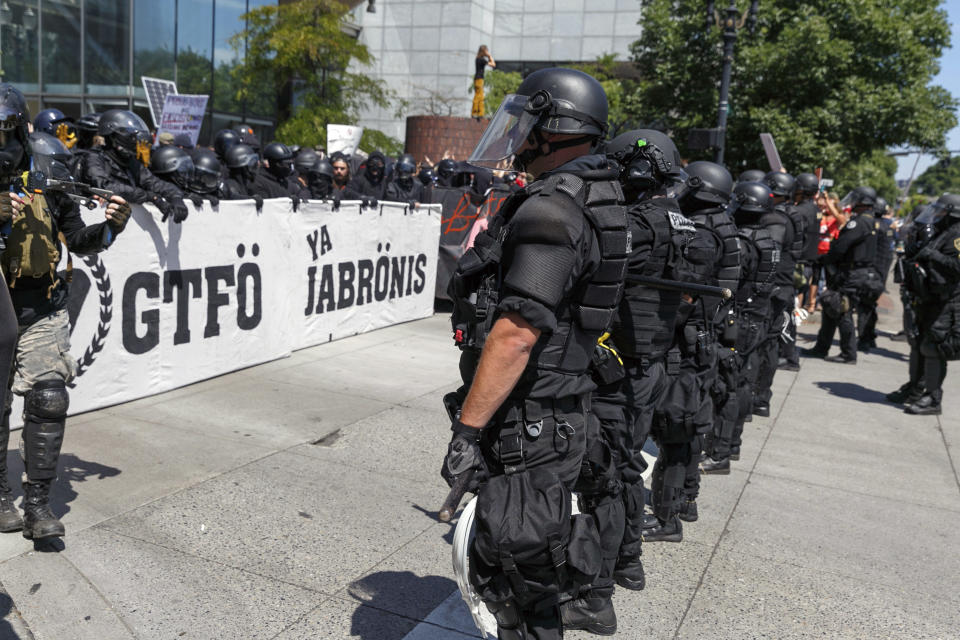 Portland police keep Patriot Prayer affiliates separate from antifa protesters during a rally in Portland, Ore., Saturday, Aug. 4, 2018.Small scuffles broke out Saturday as police in Portland, Oregon, deployed "flash bang" devices and other means to disperse hundreds of right-wing and self-described anti-fascist protesters.(AP Photo/John Rudoff)