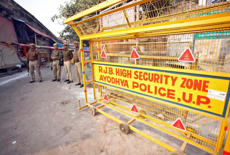 Policemen stand guard next to a security barricade on a street in Ayodhya