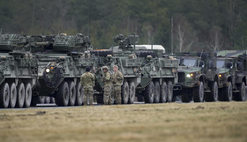 Soldiers of the 2nd Cavalry Regiment line up vehicles at the military airfield in Vilseck, Germany, Wednesday, Feb. 9, 2022 as they prepare for the regiment's movement to Romania loading of Stryker combat vehicles for their deployment to support NATO allies and demonstrate U.S. commitment to NATO Article V. The soldiers will deploy to Romania in the coming days from their post in Vilseck and will augment the more than 900 U.S. service members already in Romania. This Stryker Squadron represents a combined arms unit of lightly armored, medium-weight wheeled combat vehicles. (AP Photo/Michael Probst)