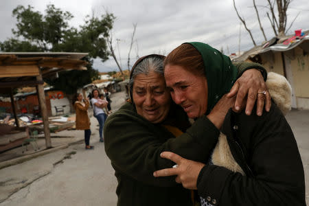 Ramona Stan, 41, is comforted by a neighbour as she leaves El Gallinero shanty town to relocate to a new apartment in Madrid, Spain, September 26, 2018. REUTERS/Susana Vera