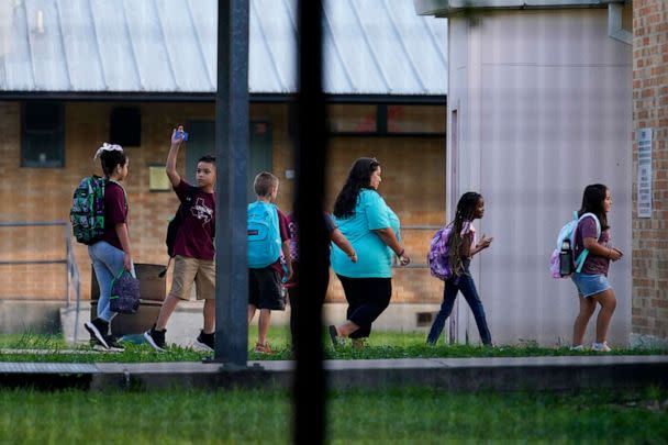 PHOTO: Students are escorted at Uvalde Elementary, now protected by a fence and Texas State Troopers, for the first day of school, Sept. 6, 2022, in Uvalde, Texas. (Eric Gay/AP)