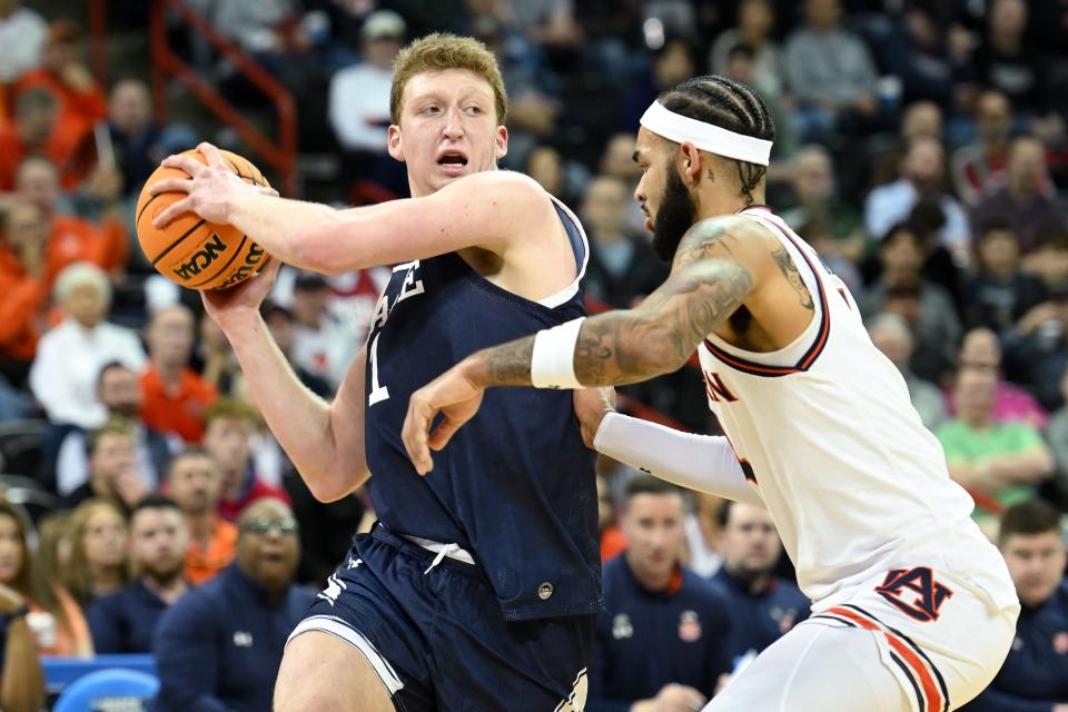 Yale Bulldogs forward Danny Wolf (1) tries to pass past Auburn Tigers forward Johni Broome (4) during the first half of a game in the first round of the 2024 NCAA Tournament at Spokane Veterans Memorial Arena.
