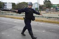 Un policía con su arma, en un enfrentamiento con opositores durante la protesta contra el gobierno de Nicolás Maduro, en Valencia Venezuela, el miércoles 26 de febrero de 2014. Las protestas iniciaron con estudiantes en distintas ciudades, quienes están molestos por el crimen, los problemas económicos y la mano dura con la que la policía les ha respondido. (AP Photo/Rodrigo Abd)