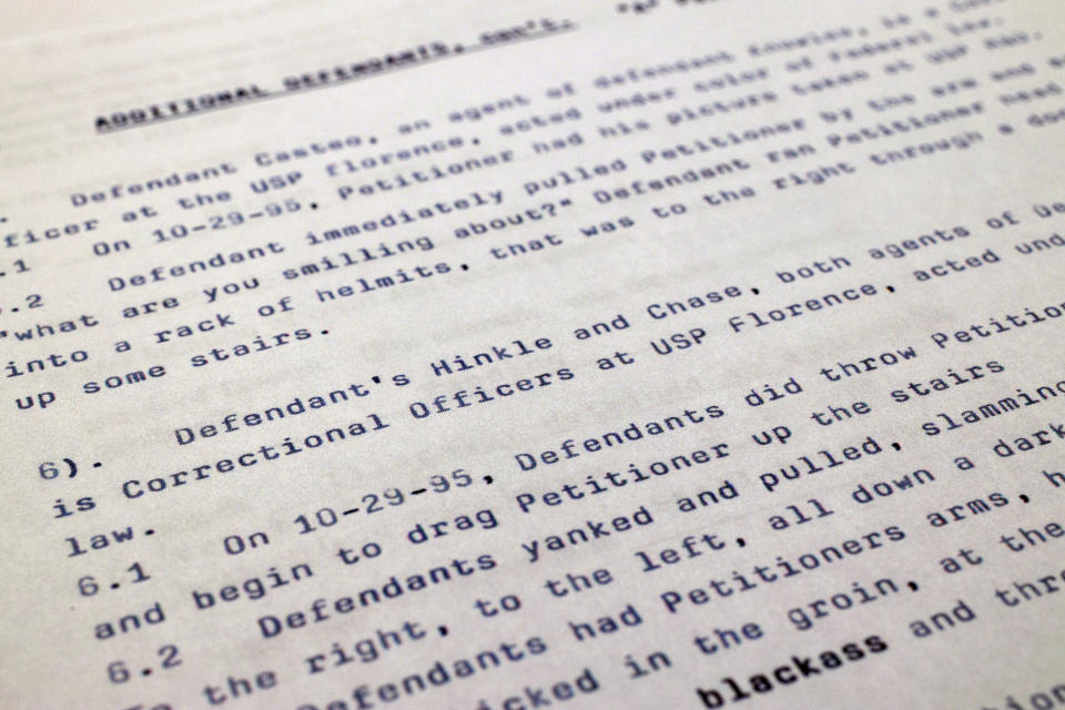 An excerpt from an April 17, 1997, prisoner civil rights complaint in which federal prison inmate Marion Bryant Jr. accuses Thomas Ray Hinkle and other guards of beating him at the federal penitentiary in Florence, Colo., is photographed on Nov. 21, 2022. Hinkle, a senior official at the federal Bureau of Prisons has been repeatedly promoted, most recently to one of the highest posts in the agency. And this has happened despite his being accused of beating multiple Black inmates in the 1990s. An Associated Press investigation has found the Bureau of Prisons has continued to promote Hinkle despite numerous red flags. (AP Photo/Jon Elswick)