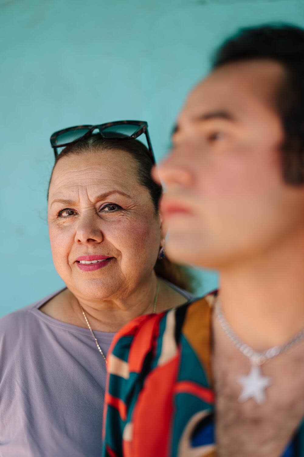 A woman in purple shirt poses with a transgender person with a star necklace.