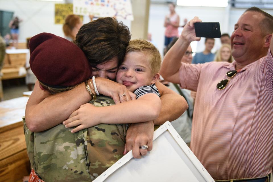 First Lt. Jordan Neeley gets a hug from her mother, Janie Neeley, and her brother, Marshall Neeley, 6, while her father, Chris Neeley, records the reunion as she returns home from a five-month deployment to Poland on Wednesday, July 6, 2022. 