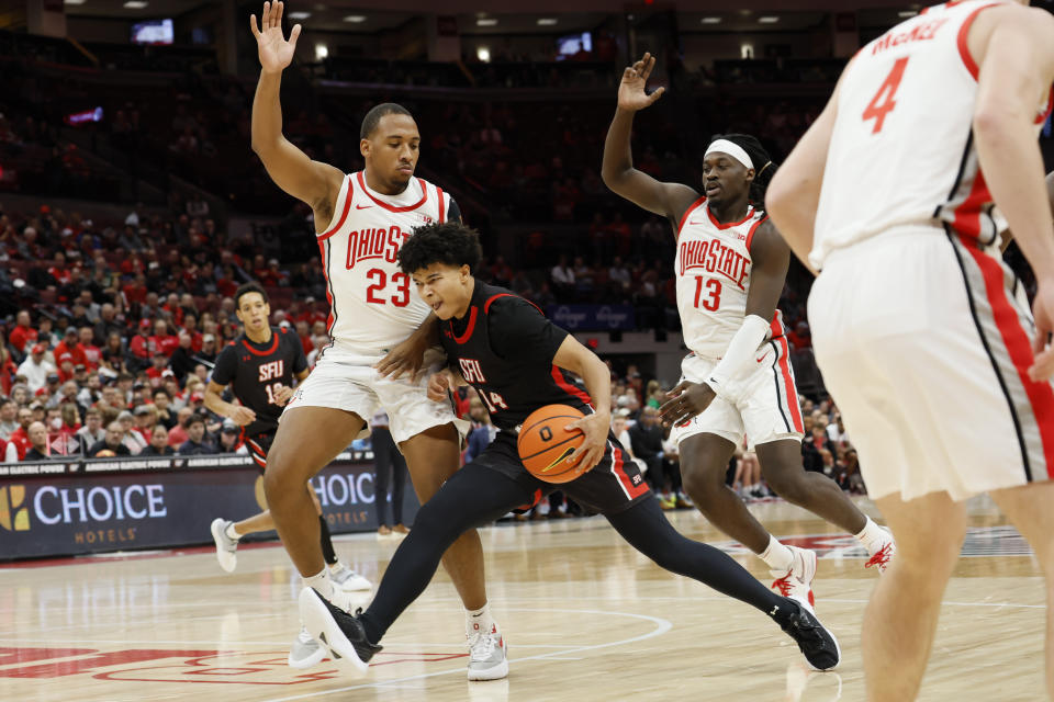 Saint Francis' Landon Moore, center, drives to the basket against Ohio State's Zed Key, left, and Isaac Likekele during the first half of an NCAA college basketball game on Saturday, Dec. 3, 2022, in Columbus, Ohio. (AP Photo/Jay LaPrete)