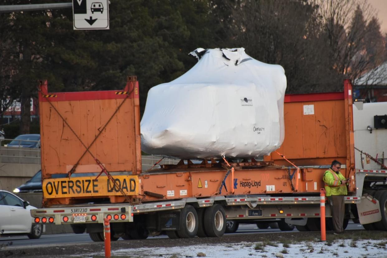 A helicopter being transported eastbound on Highway 1 struck signs hanging from the Gilmore Ave. overpass, according to the Ministry of Transportation. (Curtis Kreklau/CBC - image credit)