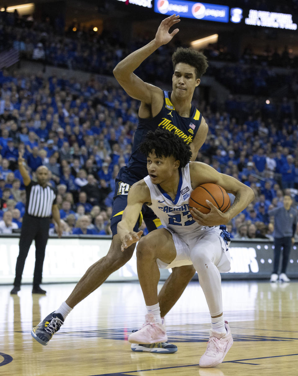 Marquette's Oso Ighodaro, top, defends against Creighton's Trey Alexander during the second half of an NCAA college basketball game on Tuesday, Feb. 21, 2023, in Omaha, Neb. Marquette defeated Creighton 73-71. (AP Photo/Rebecca S. Gratz)