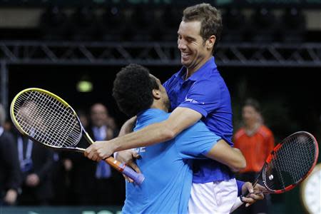 French players Jo-Wilfried Tsonga (L) and Richard Gasquet celebrate after defeating Australian players Lleyton Hewitt and Chris Guccione during their Davis Cup world group first round tennis doubles match in Mouilleron-Le-Captif, Western France, February 1, 2014. REUTERS/Stephane Mahe