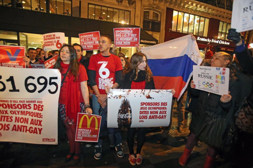 A group of gay rights activists demonstrate in front of a restaurant in Paris, Wednesday Feb. 5, 2014, to protest against Russian policy over gay rights. Gay rights activists across the world are holding a day of protests against the Russian government, just two days before the Winter Olympics begin in the southern resort of Sochi. Signs read: Sport Does Not Discriminate. Sponsors, It's Time to Say No. (AP Photo/Remy de la Mauviniere)