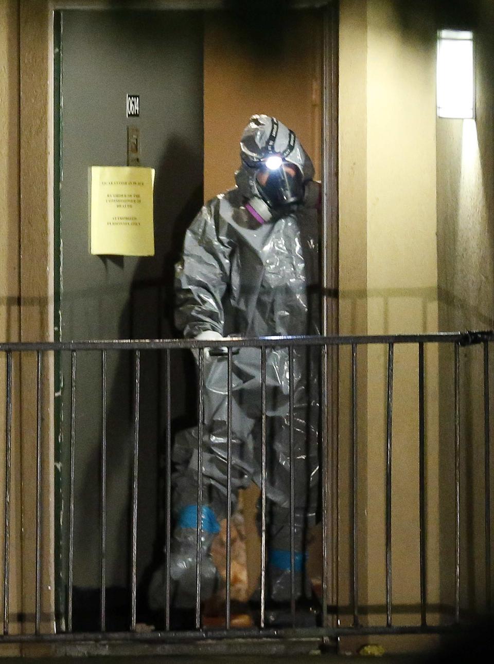 A worker in a hazardous material suit steps out of an apartment unit where a man diagnosed with the Ebola virus was staying in Dallas, Texas, October 4, 2014. (REUTERS/Jim Young)