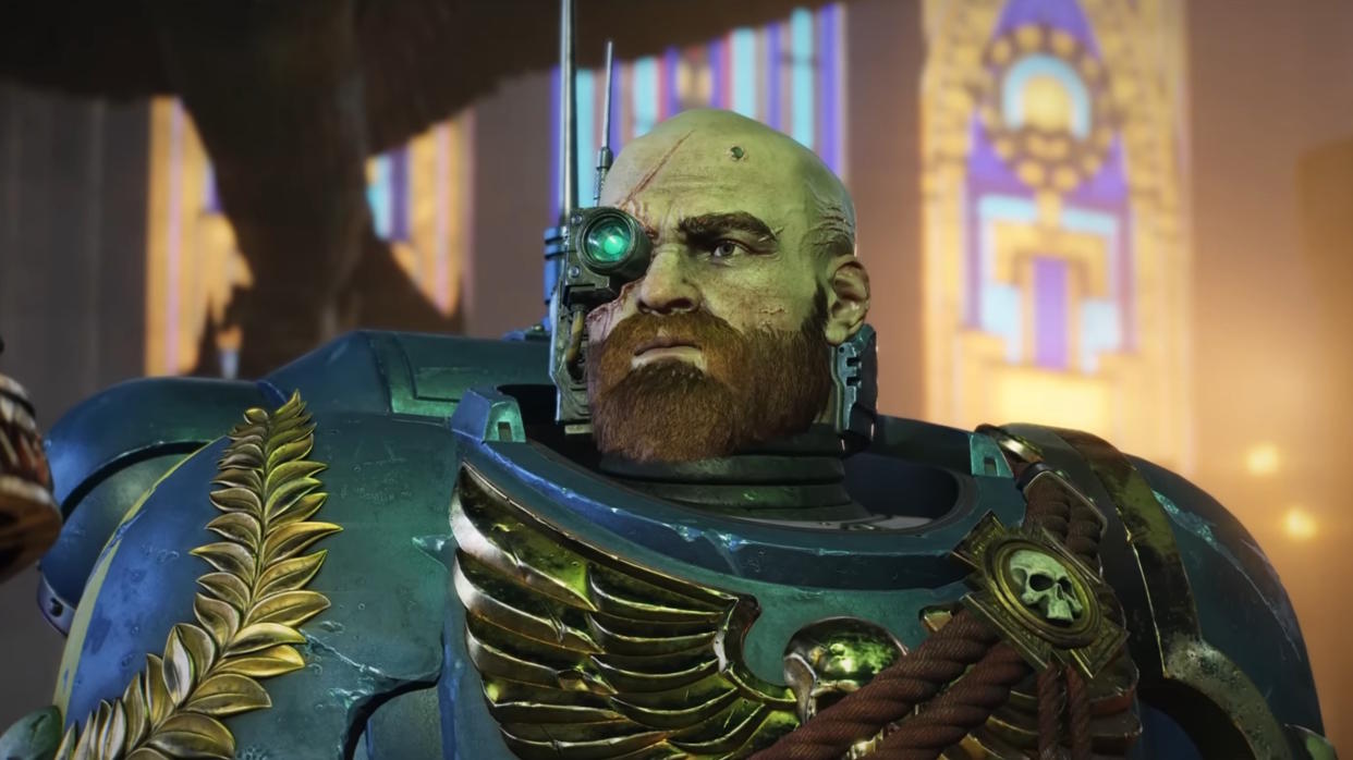  Warhammer 40,000: Space Marine 2 trailer still - close-up of a bald, bearded space marine wearing a cyber-monocle. 