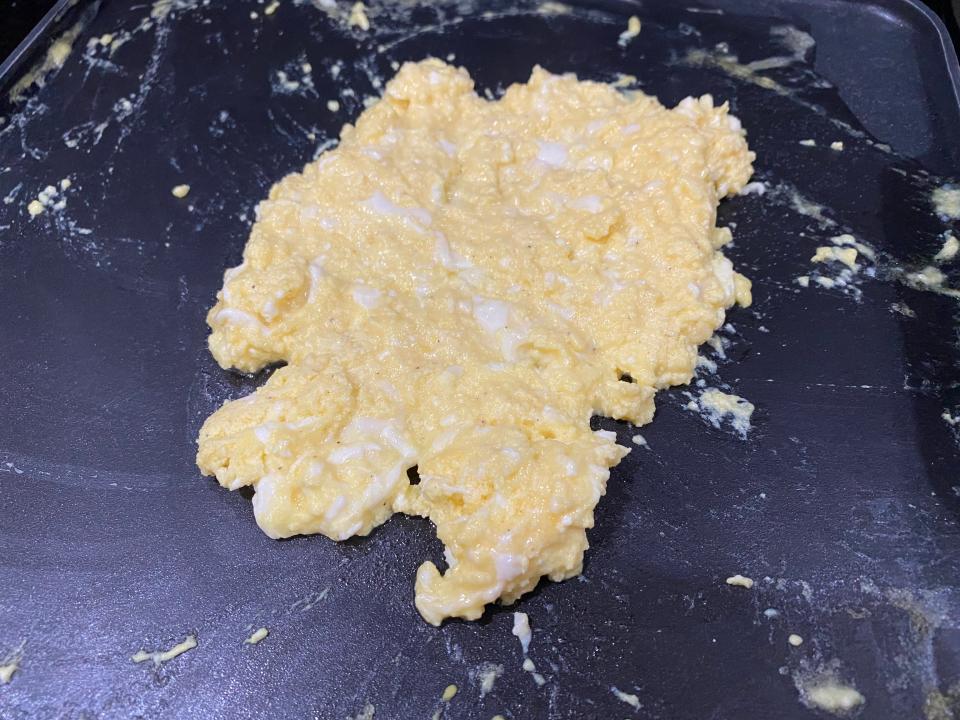 Mostly cooked scrambled eggs with Greek yogurt in a pan