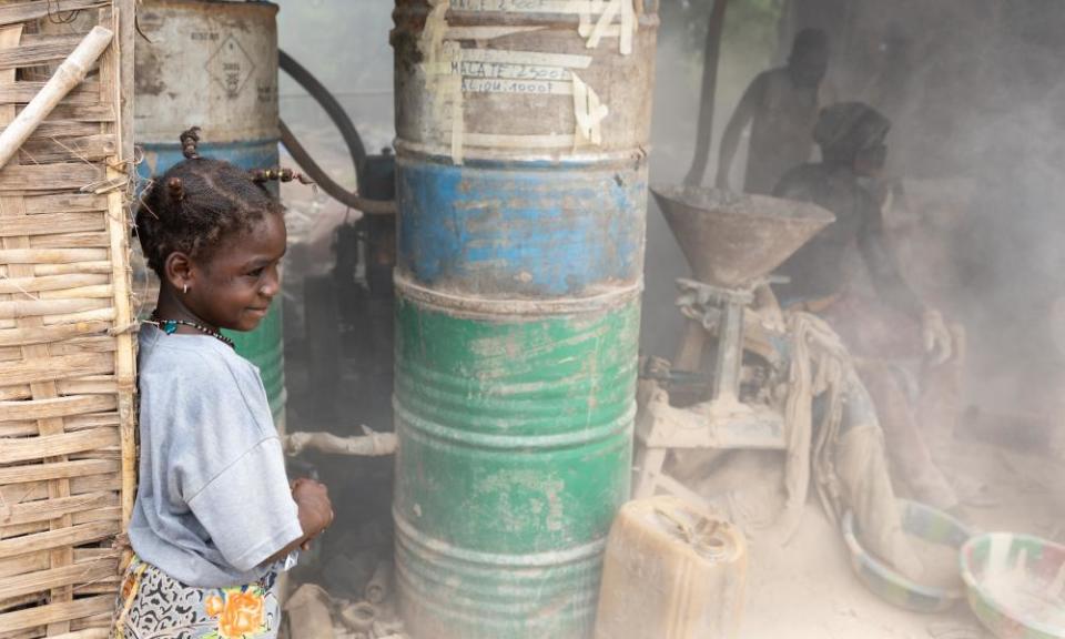 Two teenagers work equipment in hazardous, dusty conditions