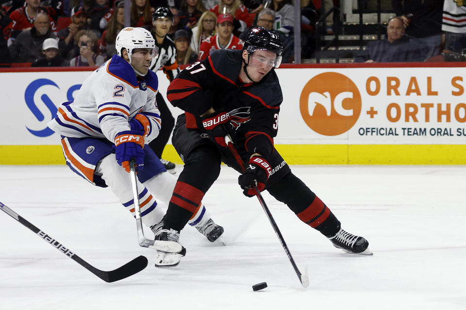 Carolina Hurricanes' Andrei Svechnikov (37) controls the puck in front of Edmonton Oilers' Evan Bouchard (2) during the second period of an NHL hockey game in Raleigh, N.C., Wednesday, Nov. 22, 2023. (AP Photo/Karl B DeBlaker)