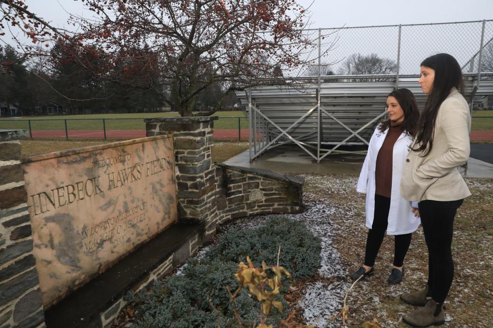 Former Rhinebeck softball players, from left Jean Pavlakis and Kaitlin Forbes visit the Maggie O'Malley memorial at Rhinebeck High School on January 12, 2023. O'Malley died from cardiac arrest in 2006. 