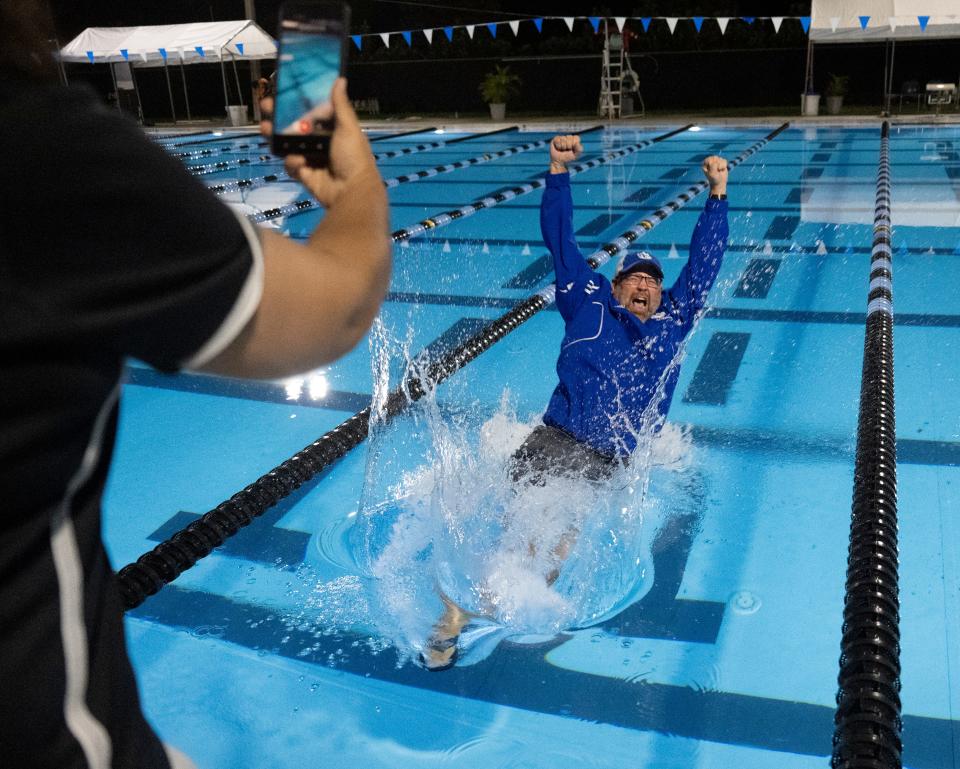 Barron Collier coach Matt Nelson jumps into the pool as he celebrates his teamÕs overall first place finish in the Collier County Athletic Conference swimming and diving championships at the Norris Aquatic Center in Naples on Thursday night, October 13, 2022.Photo by Darron R. Silva/Special to the Naples Daily News