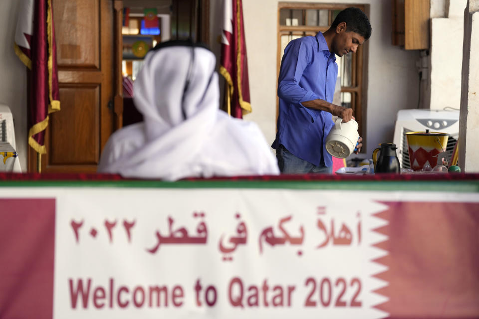 A man serves a drink at a tea house at the Souq Waqif Market in Doha, Qatar, Tuesday, Nov. 29, 2022. (AP Photo/Eugene Hoshiko)