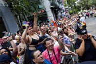 NEW YORK - JUNE 24: A NYPD officer covers her ears to hear her phone, as revelers celebrate during the New York City Gay Pride March on June 24, 2012 in New York City. The annual civil rights demonstration commemorates the Stonewall riots of 1969, which erupted after a police raid on a gay bar, the Stonewall Inn on Christopher Street. (Photo by Michael Nagle/Getty Images)