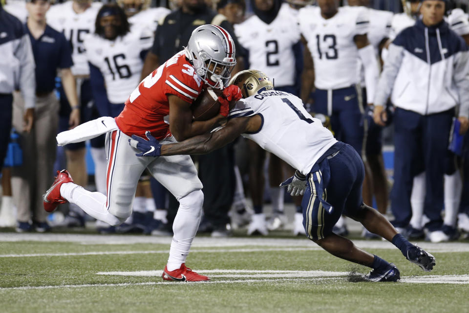 Ohio State running back TreVeyon Henderson, left, is tackled by Akron defensive back Randy Cochran during the first half of an NCAA college football game Saturday, Sept. 25, 2021, in Columbus, Ohio. (AP Photo/Jay LaPrete)