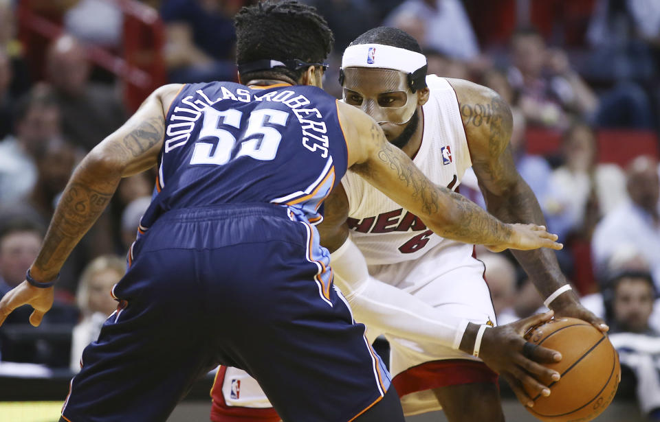 Charlotte Bobcats' Chris Douglas-Robert (55) tries to block Miami Heat's LeBron James (6) during the second half of an NBA basketball game in Miami, Monday, March 3, 2014. LeBron James scored a team recond of 61 points. The Heat won 124-107. (AP Photo/J Pat Carter)