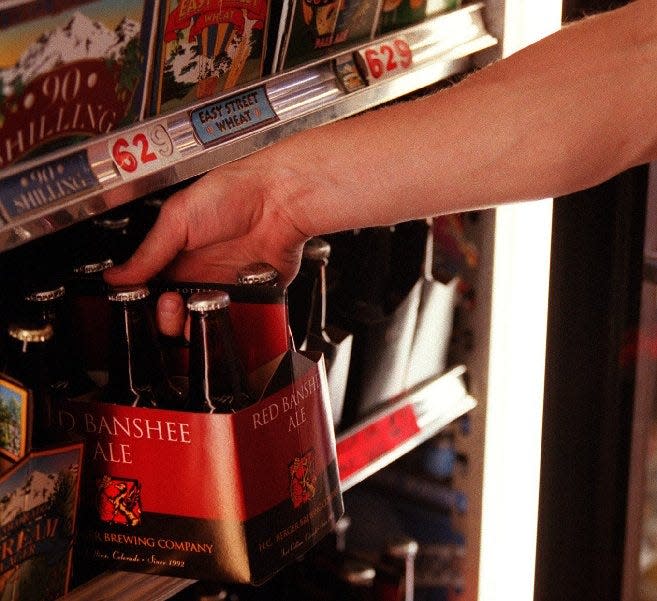 A customer pulls a six-pack of H.C. Berger's Red Banshee Ale off a shelf in 2000. While the brewery had a loyal following, it was seized by the state over unpaid taxes in 2002. H.C. Berger owner Sandy Jones opened Fort Collins Brewery in the same space the following year, reviving Red Banshee Ale along with it.
