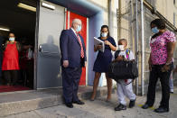FILE - In this Sept. 9, 2020, file photo, Michael J. Deegan, Superintendent of Schools for the Archdiocese of New York, center left, greets students as they wear protective masks while arriving for classes at the Immaculate Conception School in The Bronx borough of New York. New York City has again delayed the planned start of in-person learning for most of the more than 1 million students in its public school system. Mayor Bill de Blasio announced Thursday, Sept. 17, that most elementary school students would do remote-only learning until Sept. 29. Middle and high schools would stay remote through Oct. 1.(AP Photo/John Minchillo)