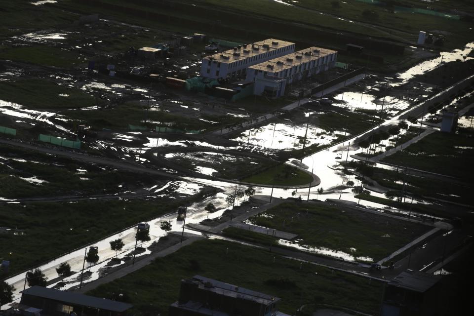 Sun light is reflected off puddles in the streets after a series of floods in Piura, Peru, Wednesday, March 22 2017. Intense rains, overflowing rivers, mudslides and flooding have hit the country, the worst seen in two decades, according to Peruvian authorities. (AP Photo/Martin Mejia)