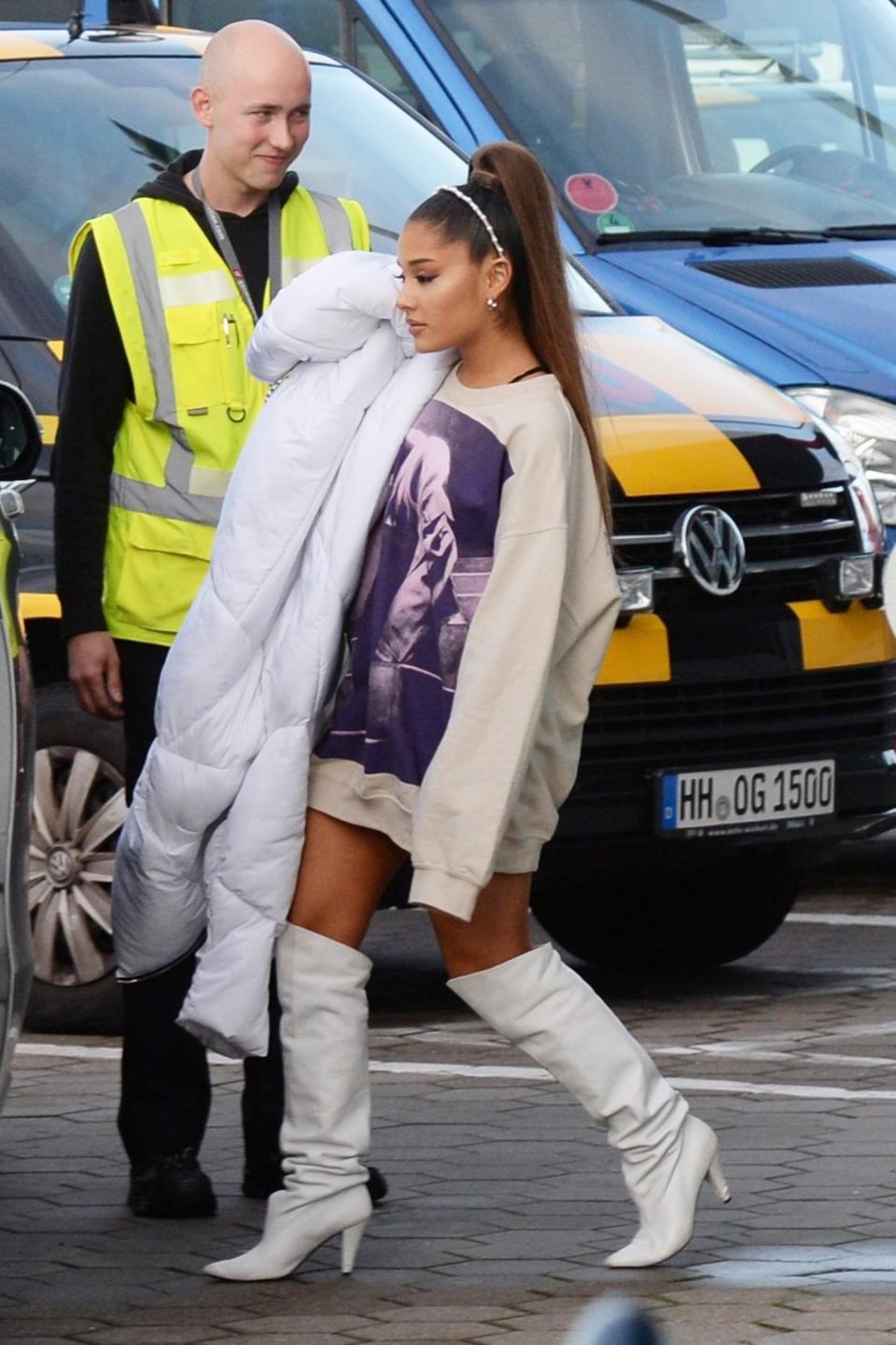 Ariana Grande hits the tarmac in white knee-high boots before boarding a private plane from Hamburg, Germany, to Berlin on Thursday. 