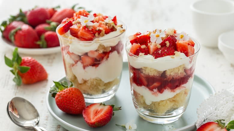 Two glasses of strawberry trifle on a green plate