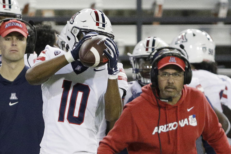 Arizona wide receiver Malachi Riley (10) catches a pass as head coach Jedd Fisch, right, watches during the second half of an NCAA college football game against Washington State, Saturday, Oct. 14, 2023, in Pullman, Wash. (AP Photo/Young Kwak)