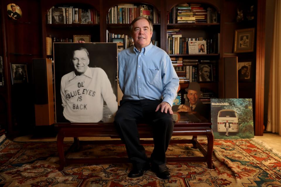 Jim Mahoney, owner of the largest collection of Frank Sinatra memorabilia in the country, with an enlarged photo of Sinatra.