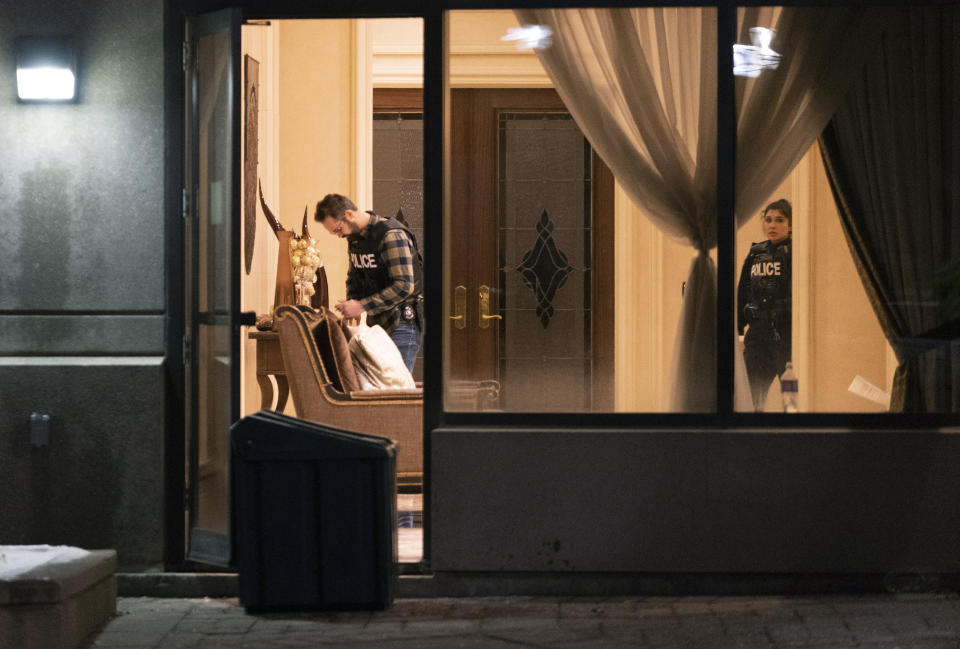 Police stand in the lobby of a condominium building following a shooting in Vaughan, Ontario, Sunday, Dec. 18, 2022. Authorities said multiple people were shot and killed in a unit of the building in the Toronto suburb and the gunman was killed by police. (Arlyn McAdorey/The Canadian Press via AP)