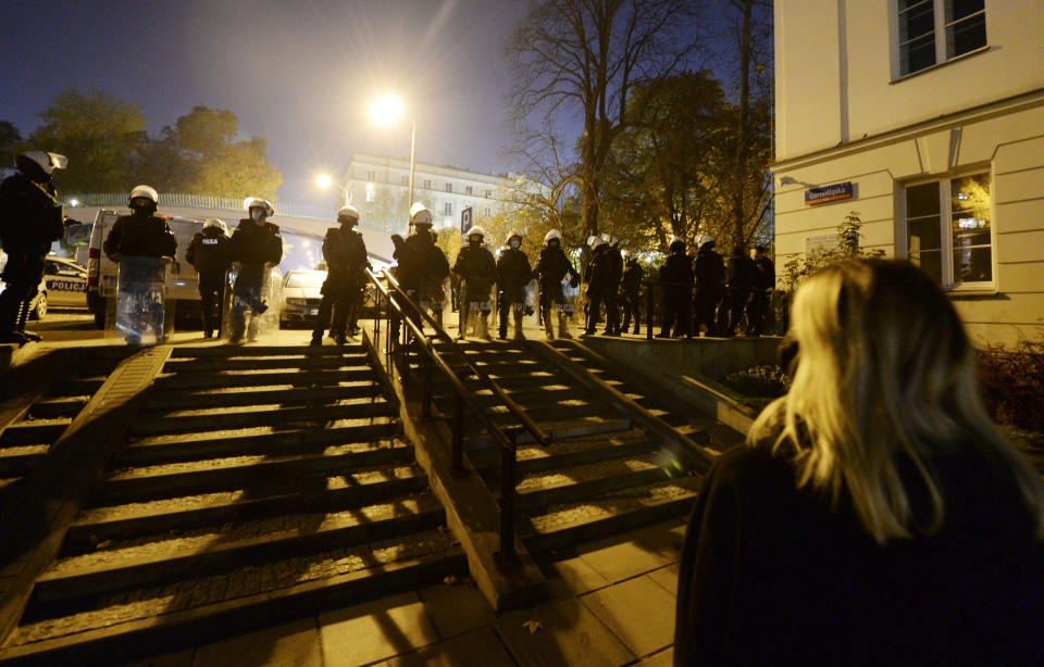 Police stand guard while protesters block the parliament in Warsaw, Poland, Wednesday Oct. 28, 2020. People across Poland stayed off their jobs and huge crowds poured onto the streets for a seventh straight day of protests Wednesday, enraged over a top court ruling that bans abortions in cases of fetal abnormalities. (AP Photo/Czarek Sokolowski)