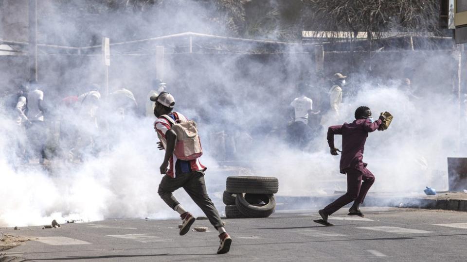 Protestors run from teargas during clashes with police in Dakar on February 9, 2024.