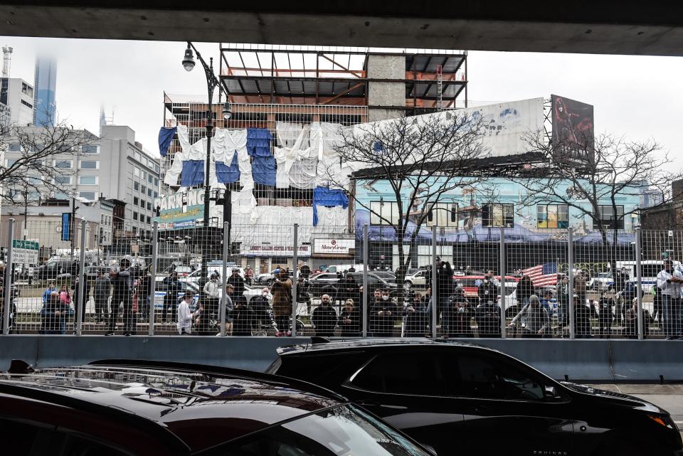 People watch as the USNS Comfort hospital ship pulls in to Pier 90 on the Hudson River on March 30, 2020 in New York City.