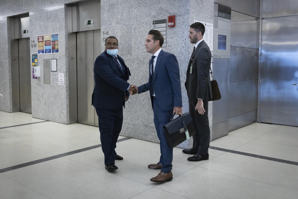 CORRECTS NAME TO LOUIS SCARCELLA NOT VINCENT SCARCELLA - Eliseo DeLeon is greeted by his lawyer Cary London in the hallway at the Kings County Supreme Court in the Brooklyn borough of New York on Wednesday Aug. 31, 2022. Justice Dena Douglas rendered a guilty verdict in the first retrial to result from almost a decade of scrutiny of former New York City homicide detective, Louis Scarcella, who was seen as a case-cracking star in the 1980s and '90s, but was later accused of framing suspects. (AP Photo/Stefan Jeremiah)